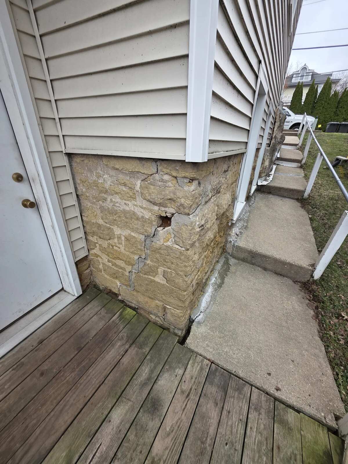 Cracked, settled concrete steps along the side of a house before replacement